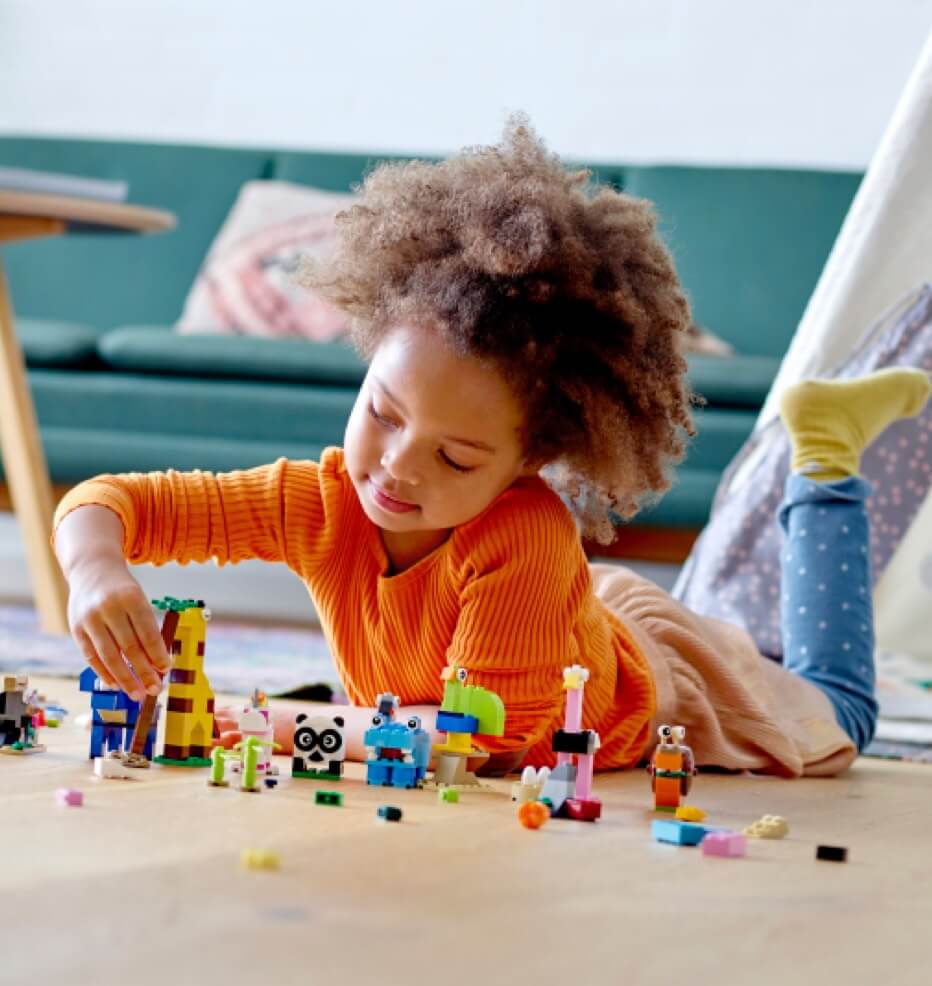 A child playing with LEGO on the floor.