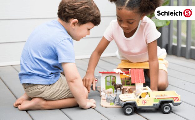 Two kids playing with a Schleich® playset.