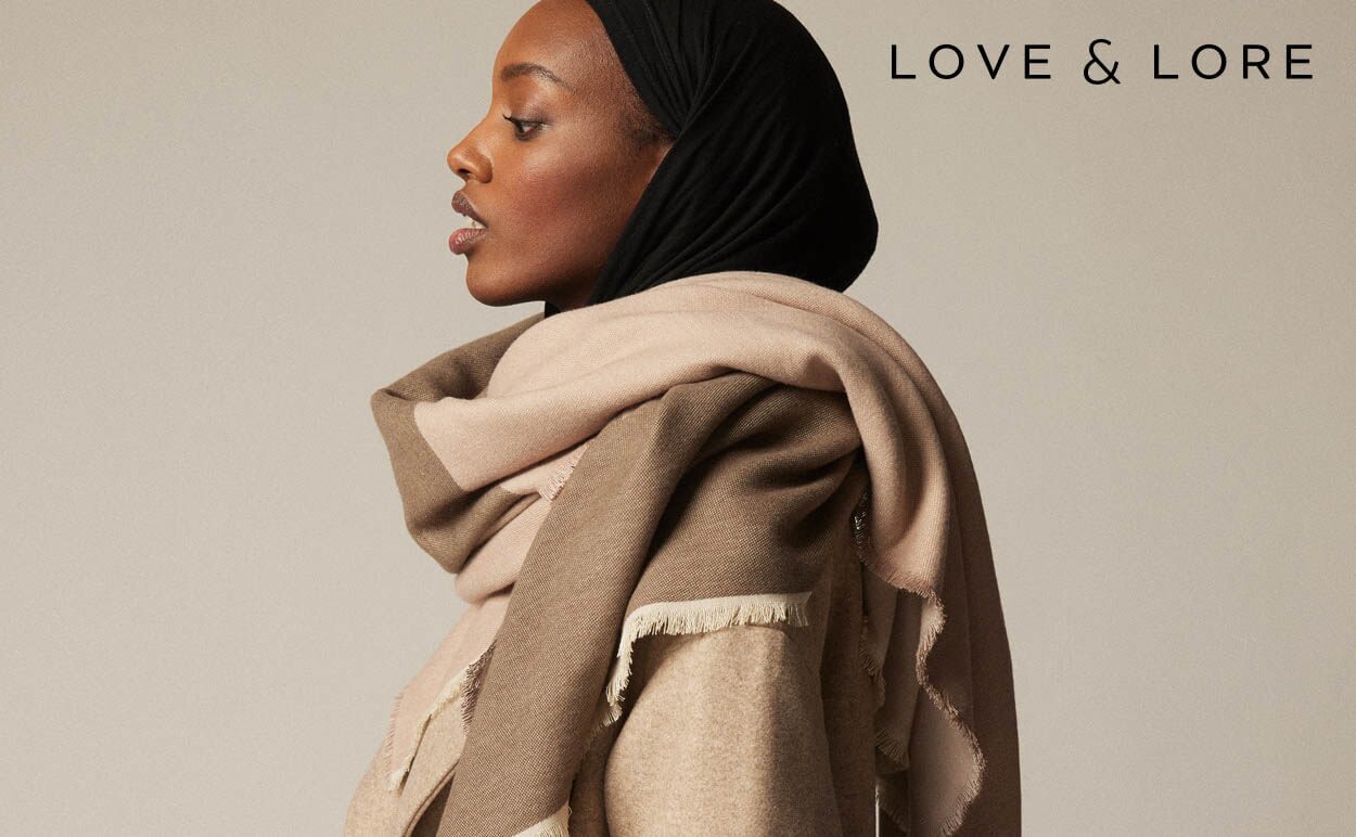 A woman wearing a Love & Lore blanket scarf.