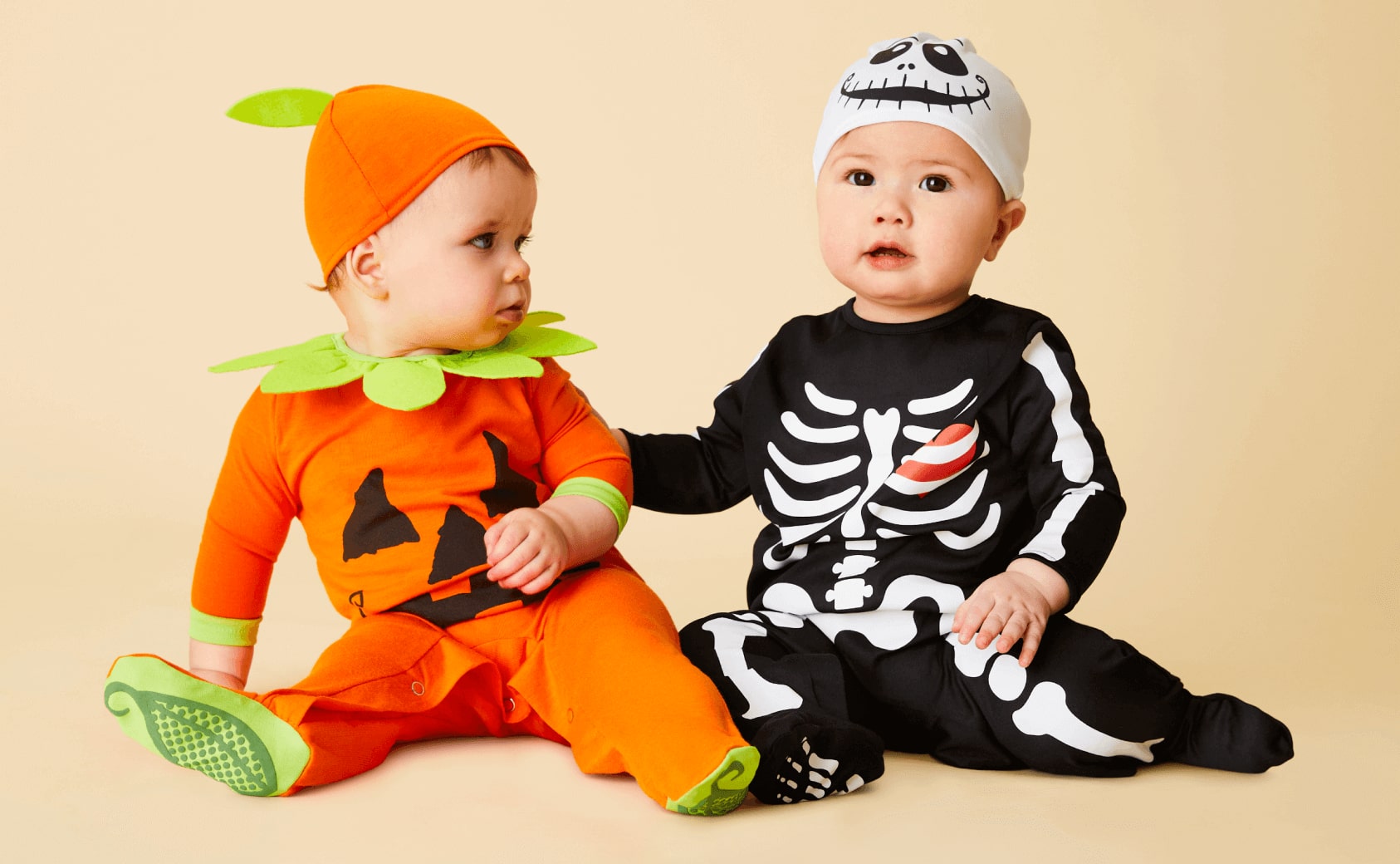 Two babies in halloween costumes.