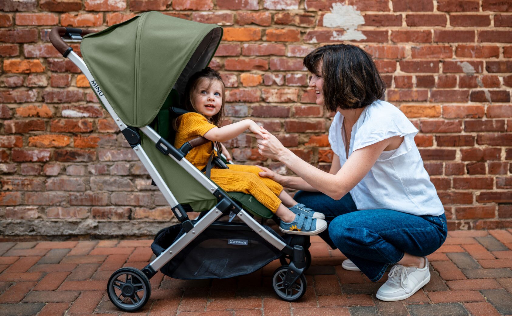 A baby sitting in the Minu Travel stroller from UPPAbaby.