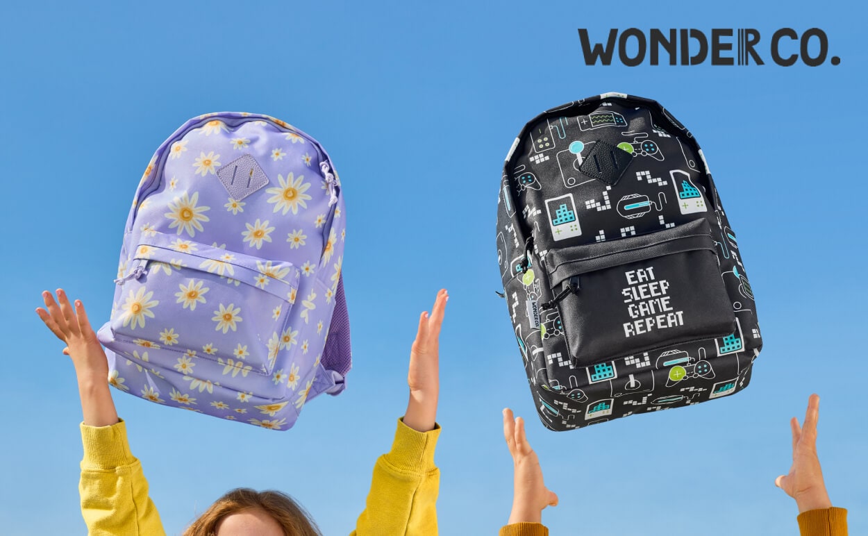 Two kids throwing Wonder Co. backpacks in the air.