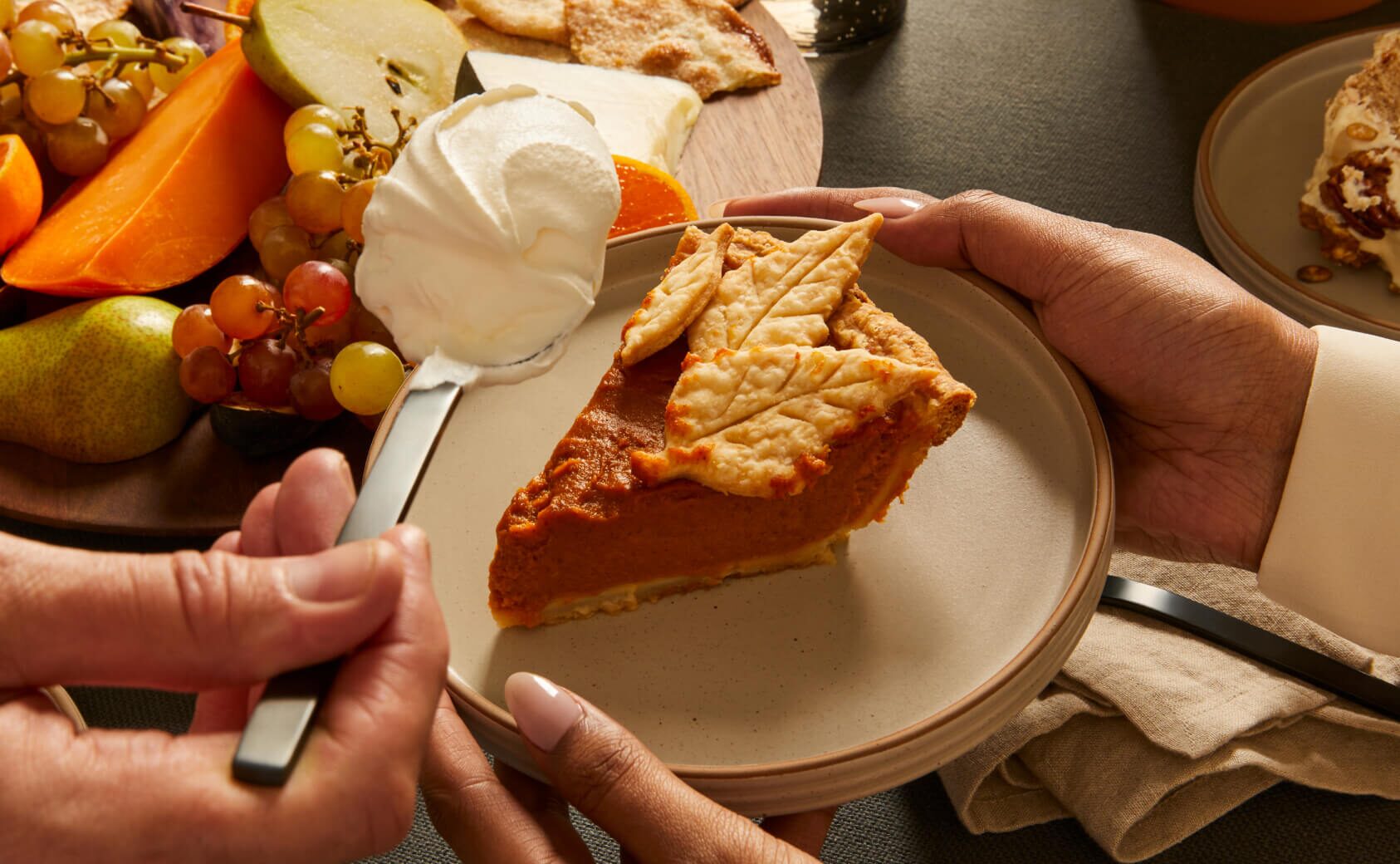 Pumpkin pie being served on a OUI ridged ceramic plate with a dollop of whipped cream.