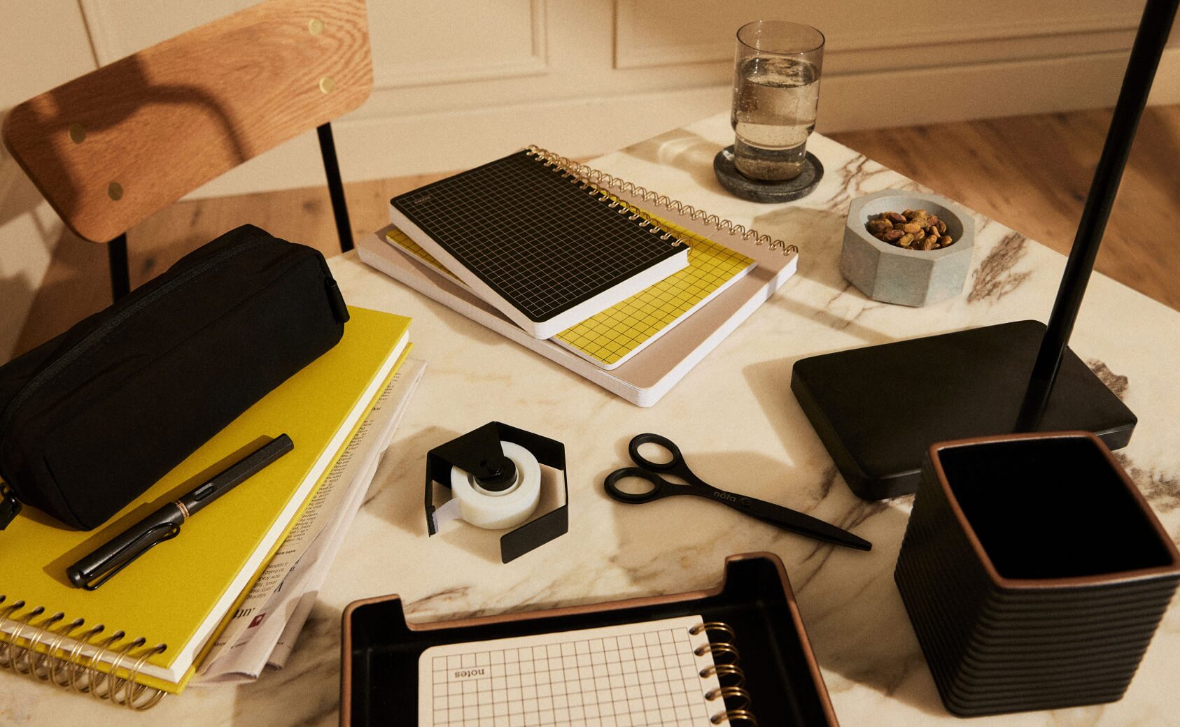 A desk with notebooks and office supplies from nóta's Artisan collection.