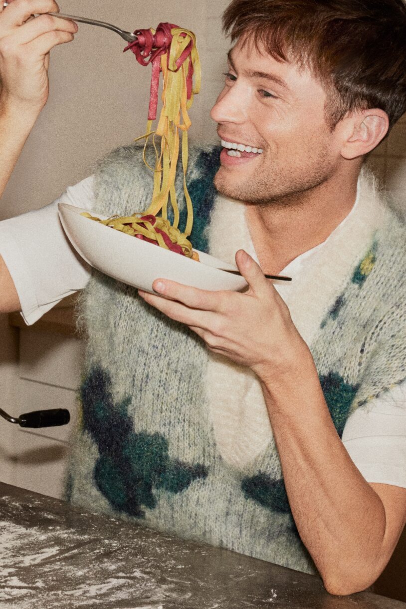 Smiling man holding a bowl of pasta
