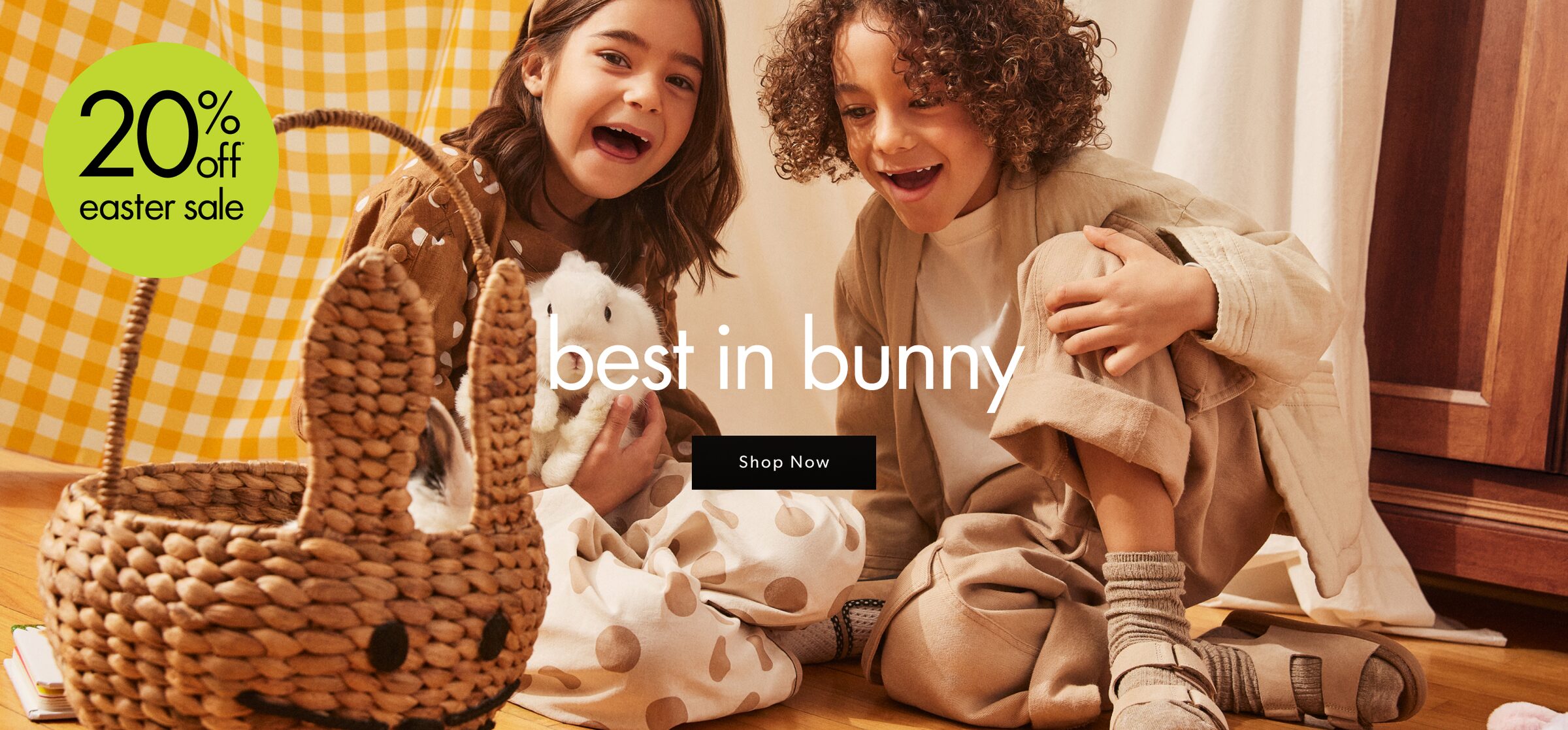 Children sitting next to an Easter basket while holding a bunny.