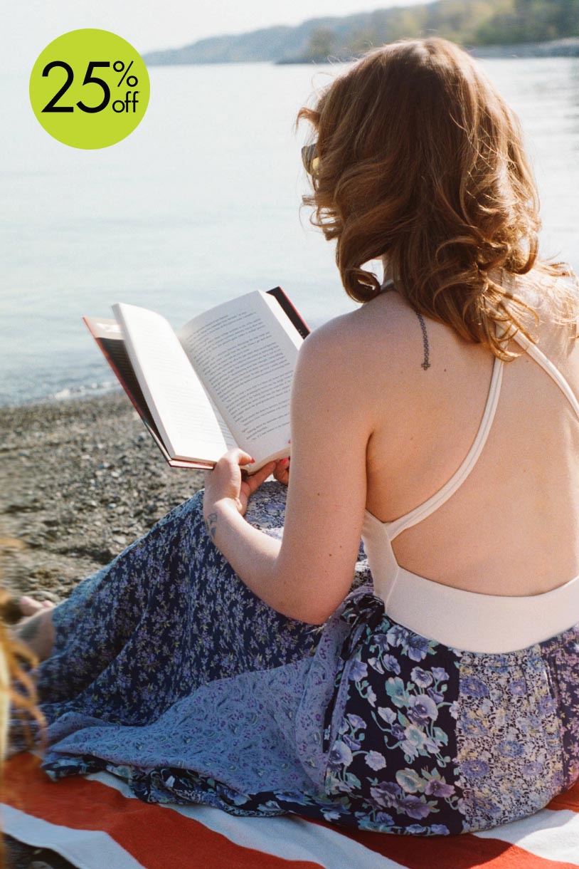 A woman reading a book on the beach